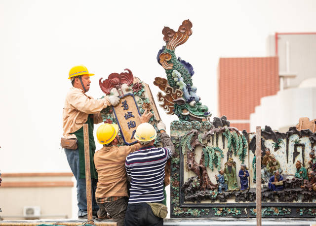 中山市小榄镇永宁玅灵宫，工人对陶塑瓦脊进行拼装。吴景标摄