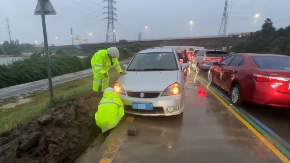 风雨中，小车不慎陷入凹坑！警辅人员合力抬车助脱险