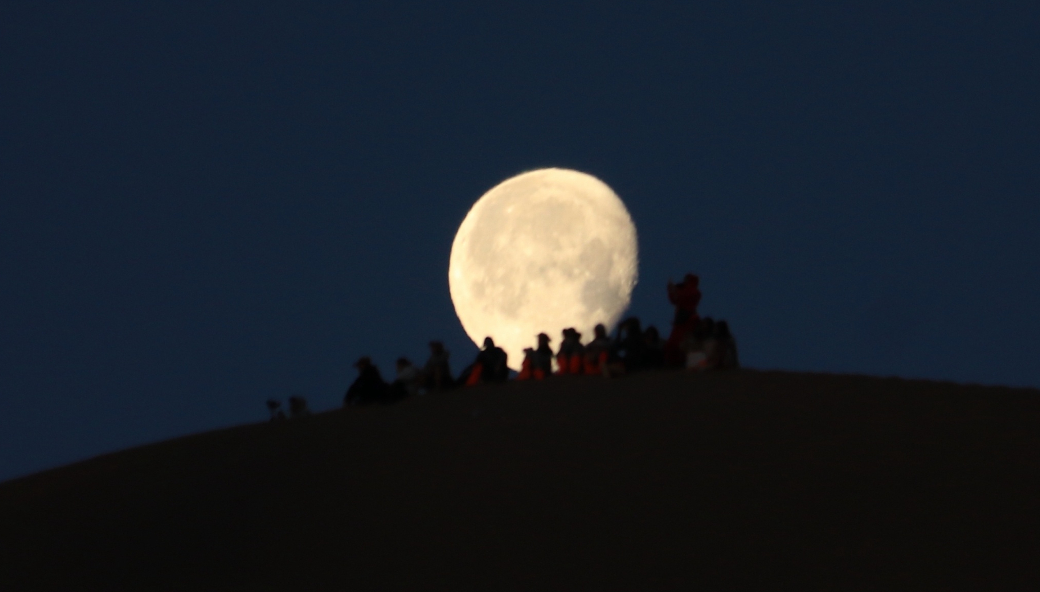 游客在酒泉鸣沙山上赏月
